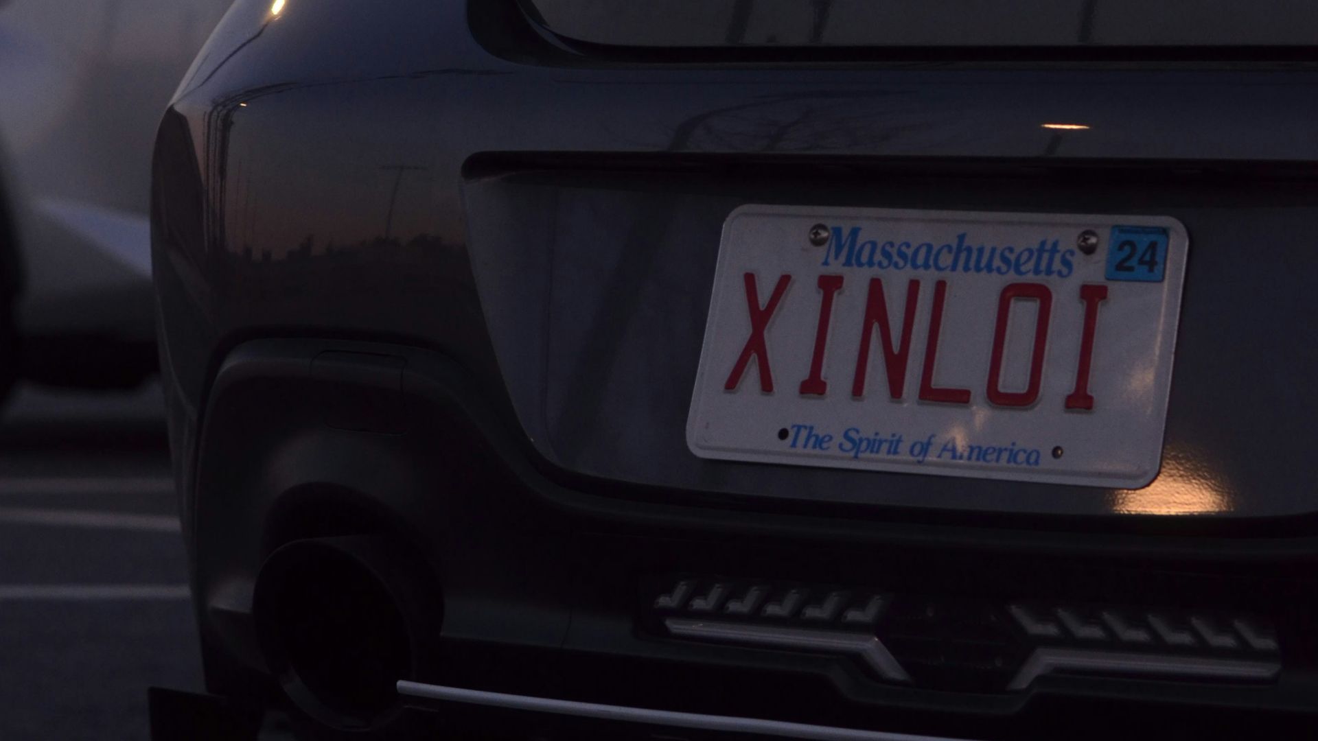 a car parked in a parking lot next to another car