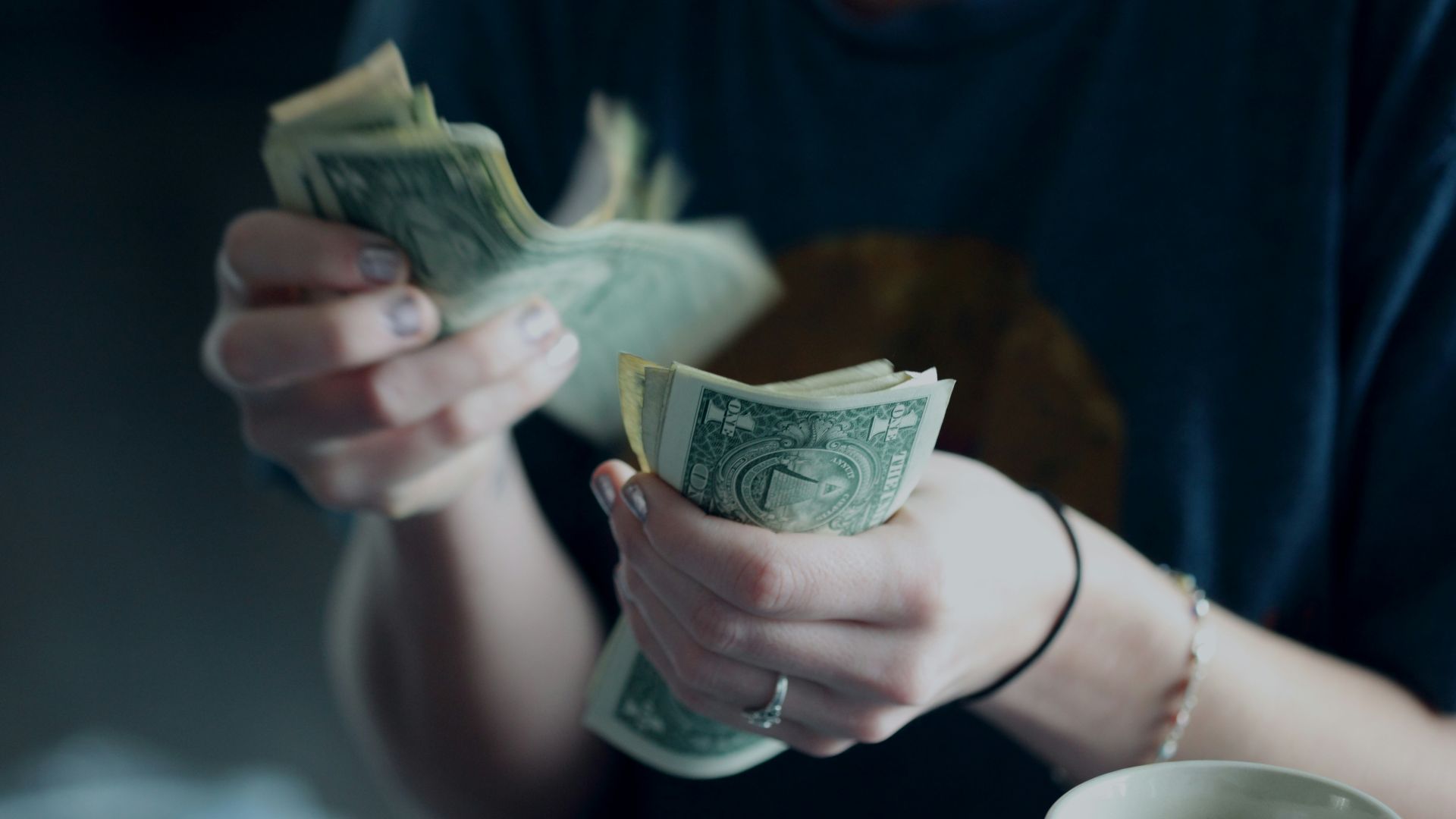 focus photography of person counting dollar banknotes