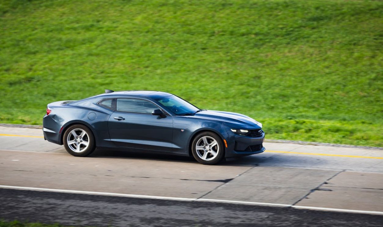 Sleek Black Sports Car Driving on Highway
