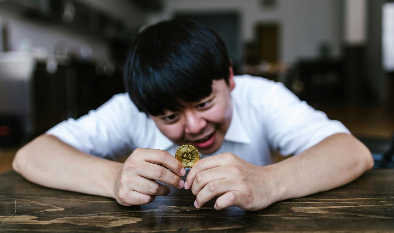 Man looking at a Gold Coin
