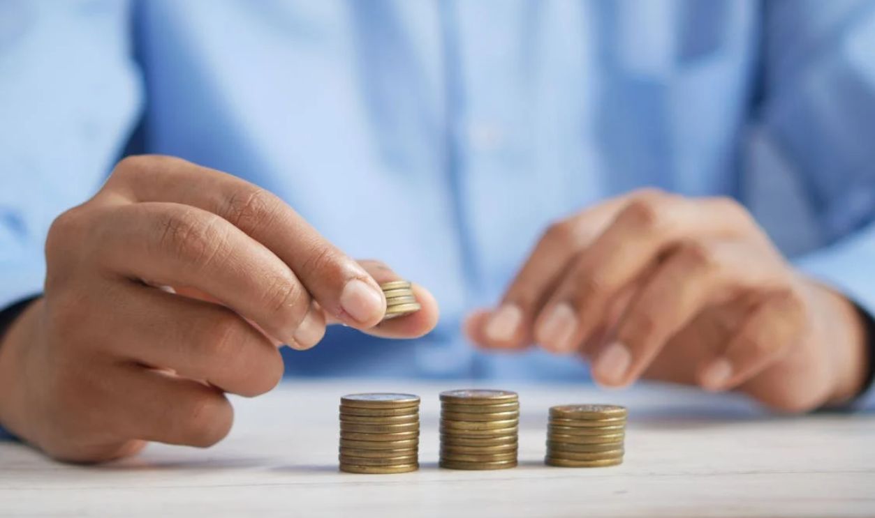 A Close-Up Shot of a Person Stacking Coins