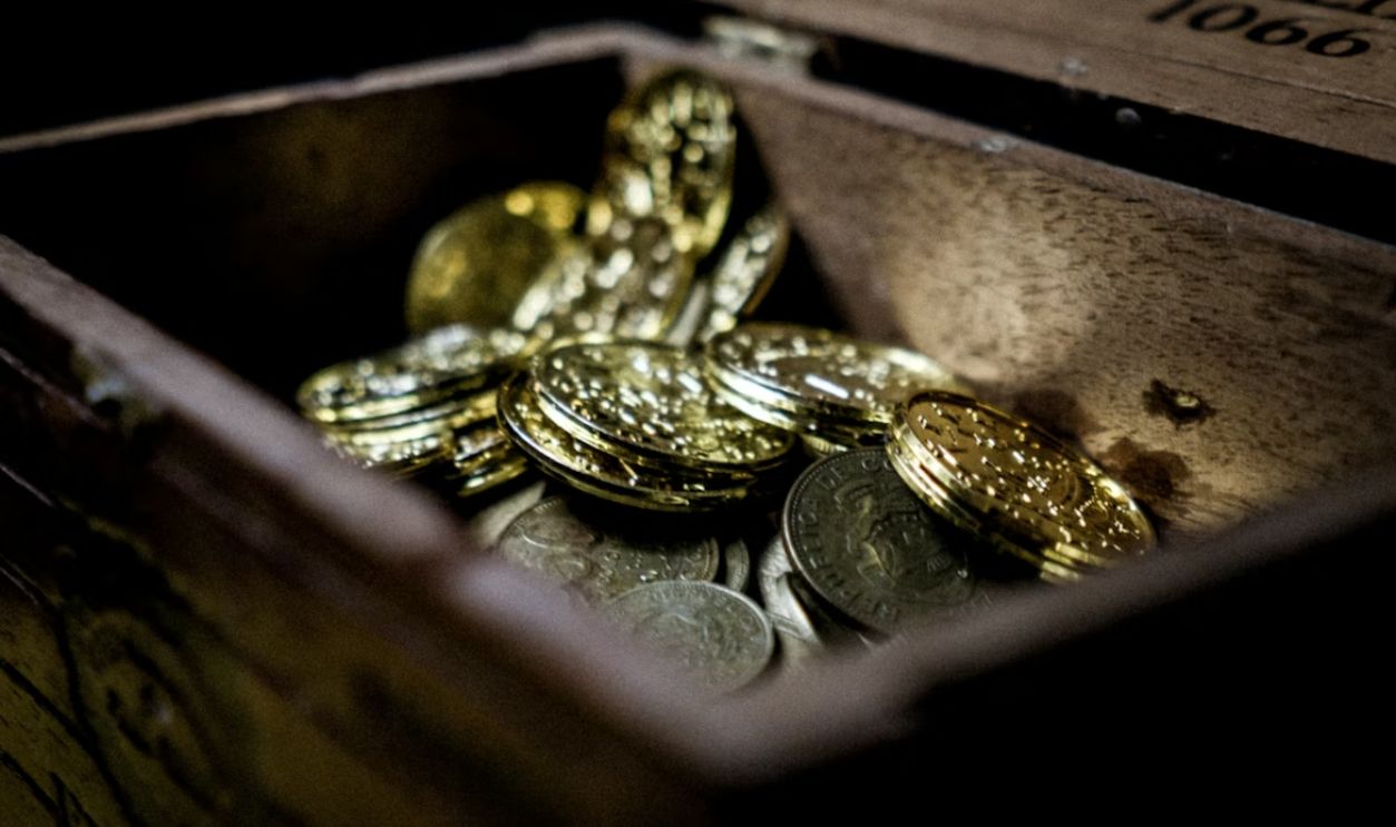 a wooden box filled with lots of coins