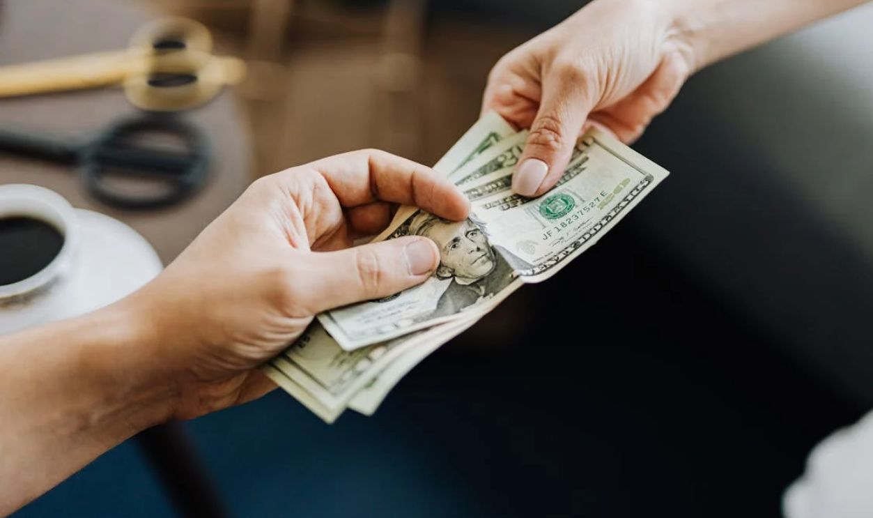 Hands Holding Us Dollar Bills