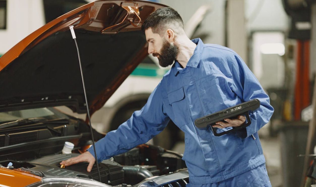 Mechanic Checking the Engine of a Car