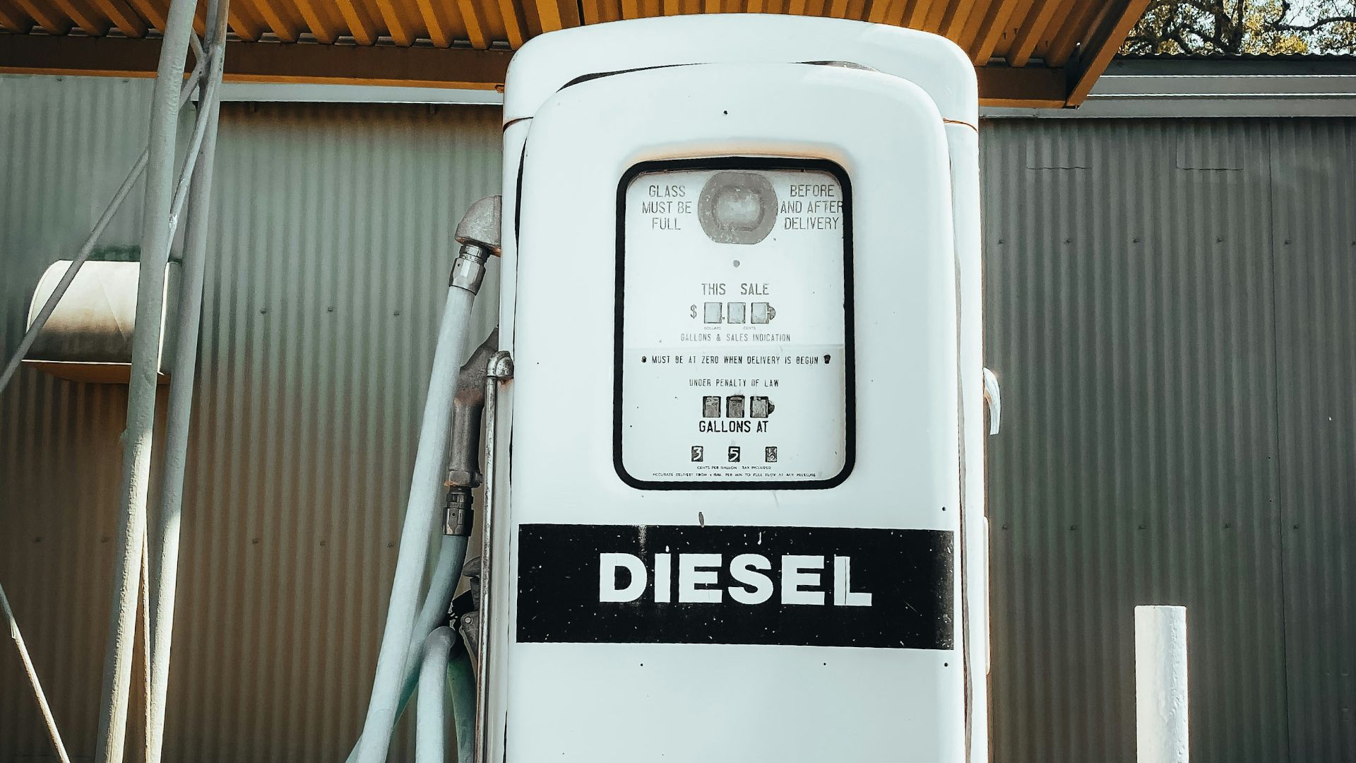 an old diesel gas pump with a hose hooked up to it
