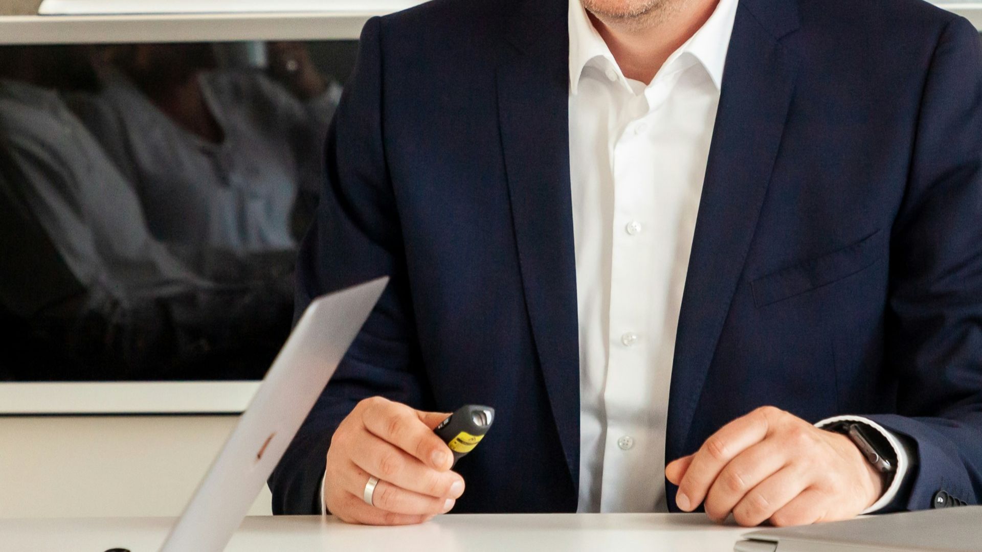 Man in suit smiling in front of a diagram
