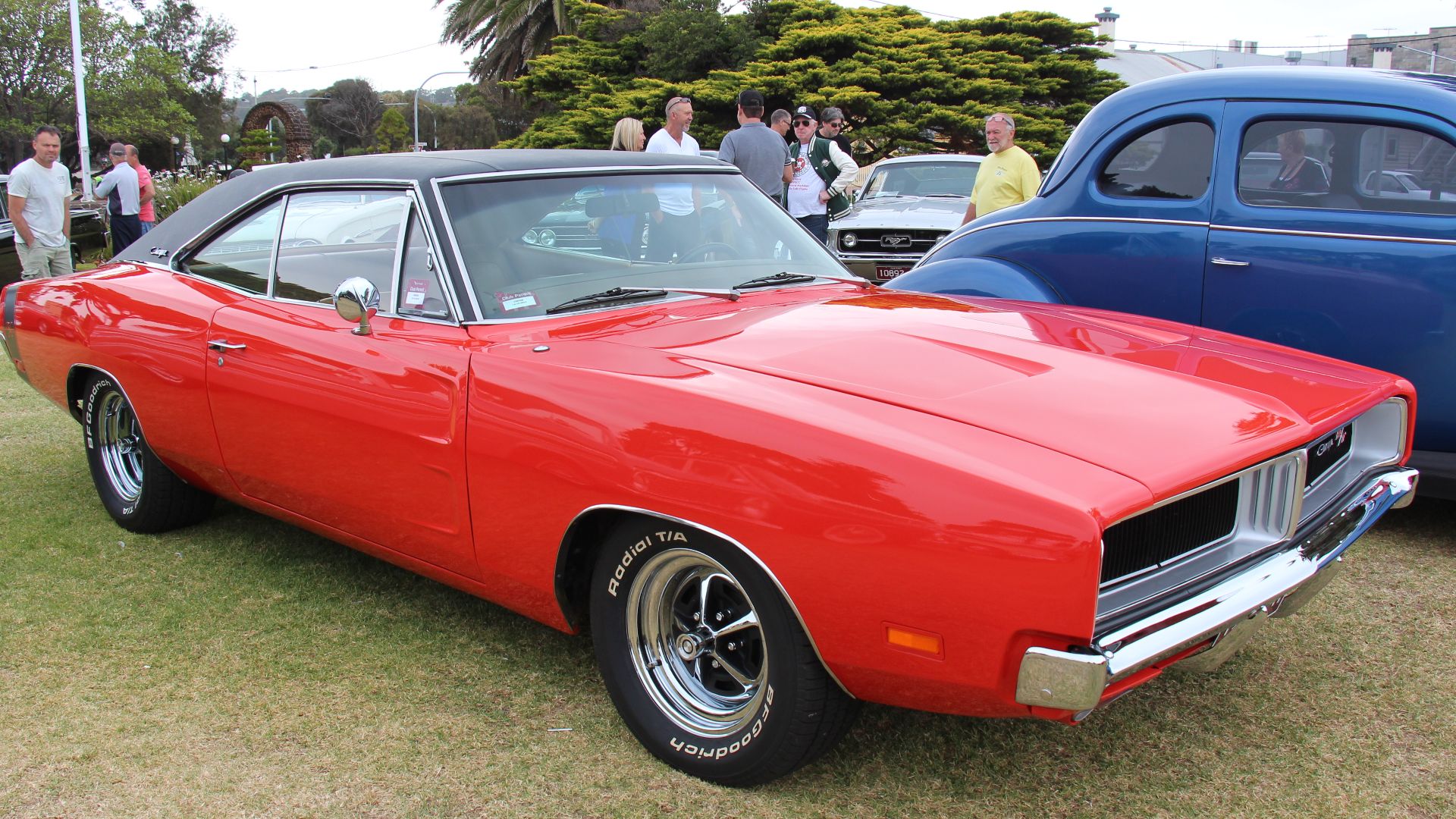 Charger Red. 
From 1966 the B Body Dodge (same platform as the Plymouth Belvedere and Satellite) was available as the general Coronet or the 2 door muscle car, the Charger. It was redesigned in 1968 loosing the fastback styling and getting a 'coke bottle' shape. A facelift in 1969 saw a now divided grille and longitudal tail lights. A new option available was the upmarket SE with leather, woodgrain and chrome. Also new was the NASCAR inspired 500, a more aerodynamic car with flush back window and flush Coronet grille and also later the NASCAR ready Daytona, even more aerodynamic with 18 in nose and 23 in tail wing.
Engines;  225 cu in slant 6, 318, 383 V8s. 

RT, 500 and Daytona models came standard with the 440 and the 426 Hemi was a option