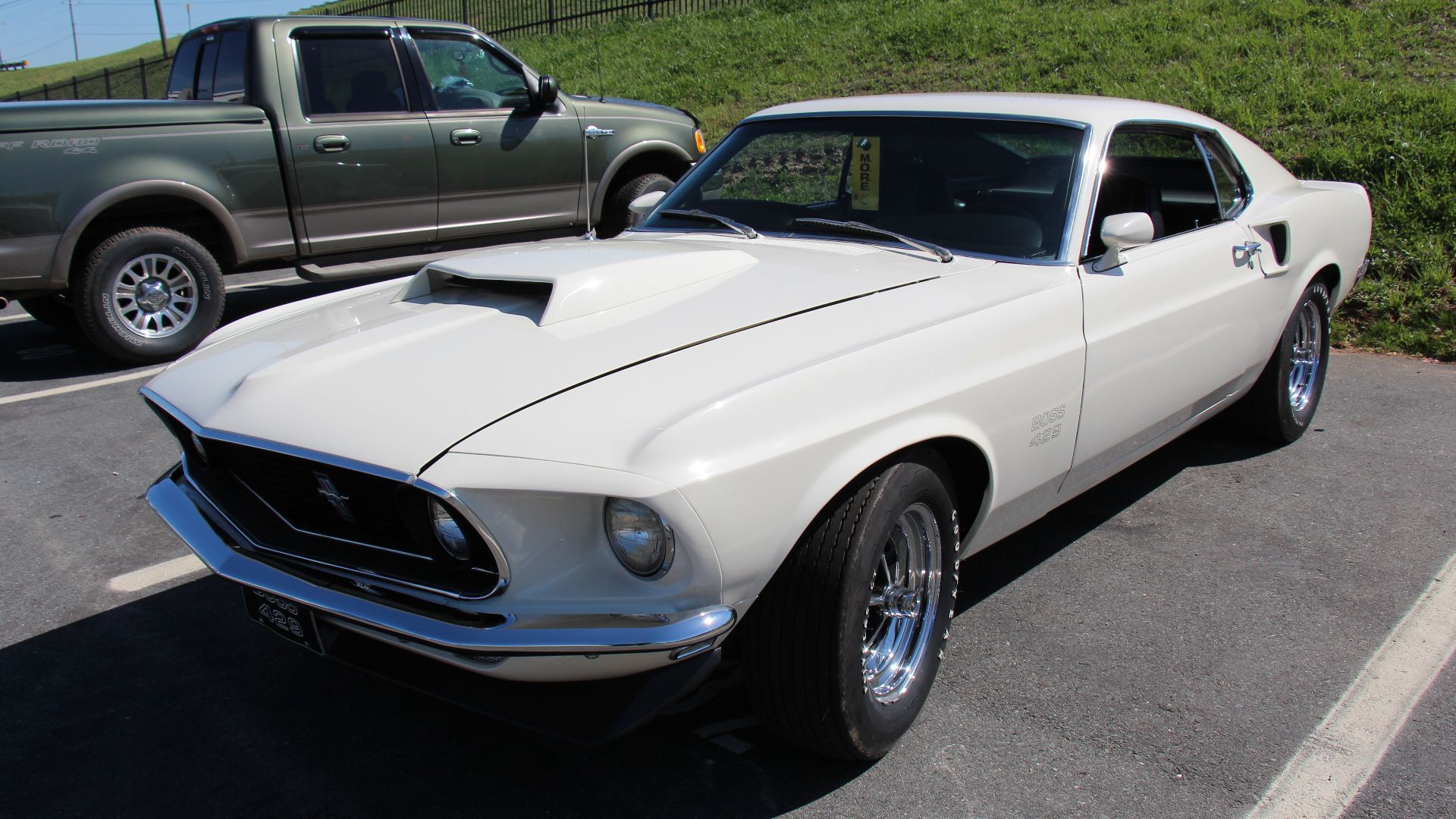 Wimbledon White. 
The 1969 Mustang got a new body, nearly 4 inches longer than the 1968 model. The Fastback was now called the Sportsroof. 
The Boss 429 was born of Ford's need to qualify 500 examples of its new racing engine for NASCAR. But instead of putting production units in the midsize Torinos it ran in stock-car racing, Ford offered the engines in the 69 and 70 Mustangs. It was a serious mill: four-bolt mains, a forged steel crankshaft, and big-port, staggered-valve aluminum heads with crescent-shaped combustion chambers, 735-cfm Holley with ram-air, an aluminum high-riser, and header-type exhaust manifolds. Outside, simple decals, front spoiler, Magnum 500 wheels and hood scoop (Body colour for 69, black for 70).
859 1969 Boss 429s were made, including 2 Boss Mercury Cougars

Photographed at the 50th Anniversary of the Mustang celebrations at the Charlotte Motor Speedway, April 2014