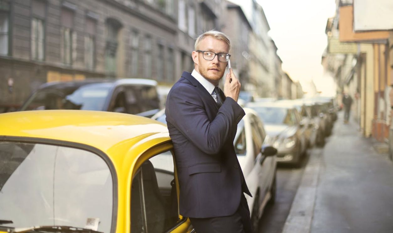 Man in Black Suit Jacket While Using Smartphone