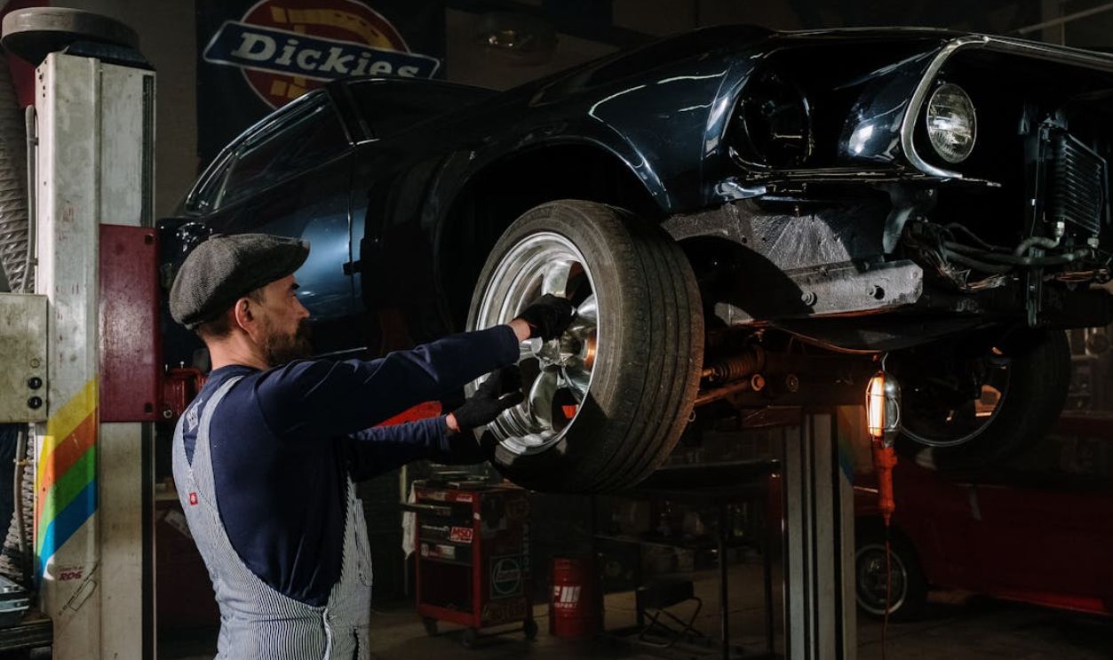 Man in Blue Long Sleeve Shirt and Gray Pants Standing Beside Black Car