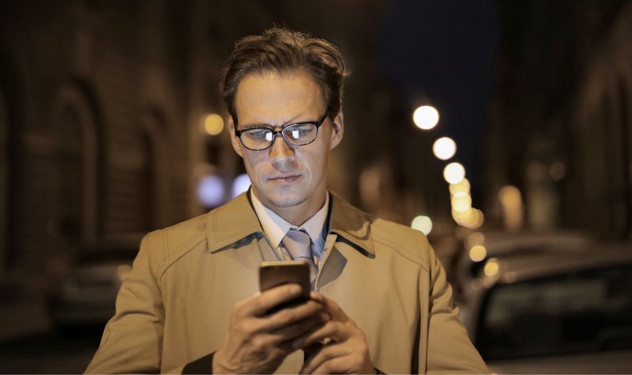 Serious businessman using smartphone on street