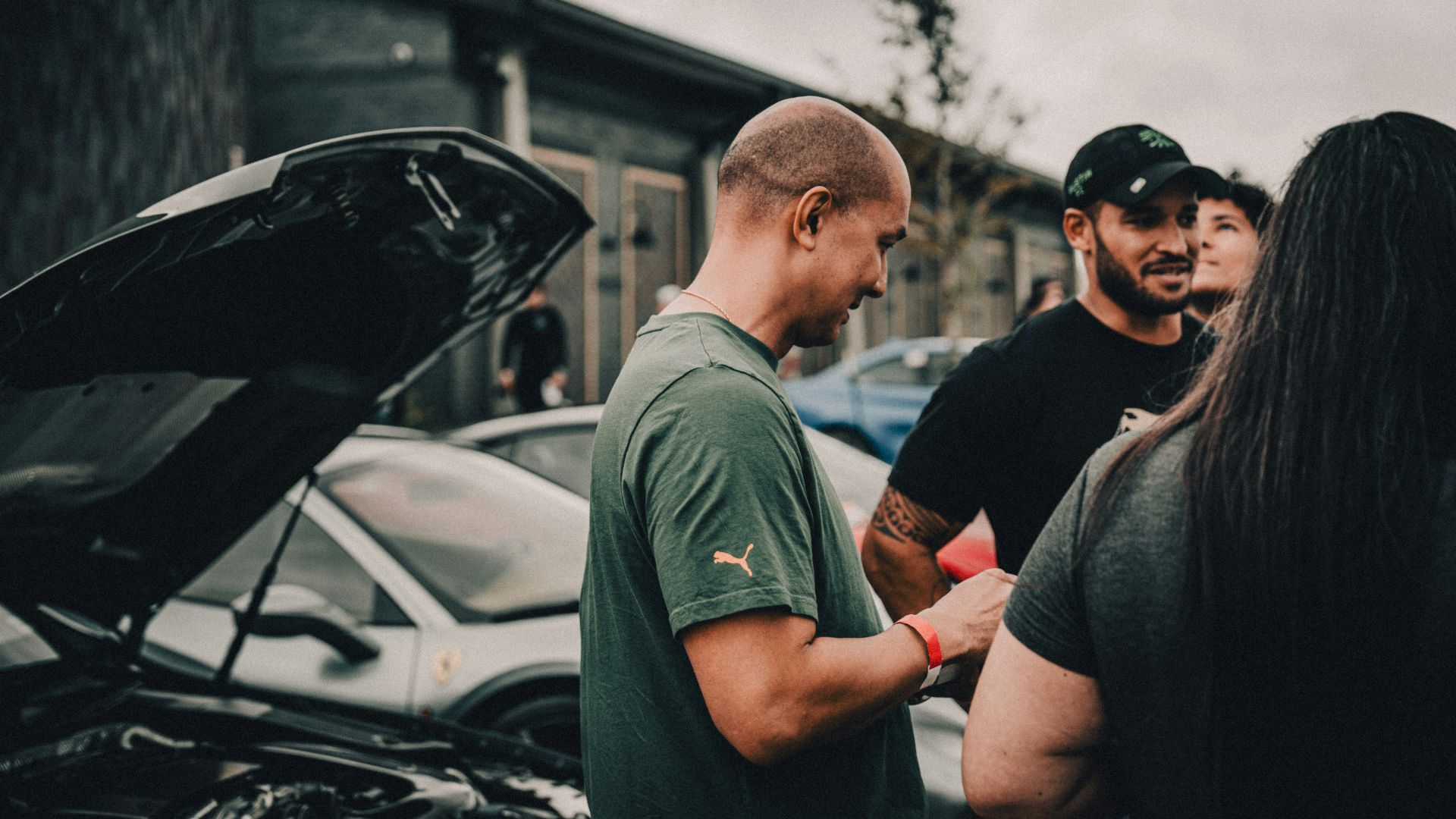 A group of people standing around a parked car