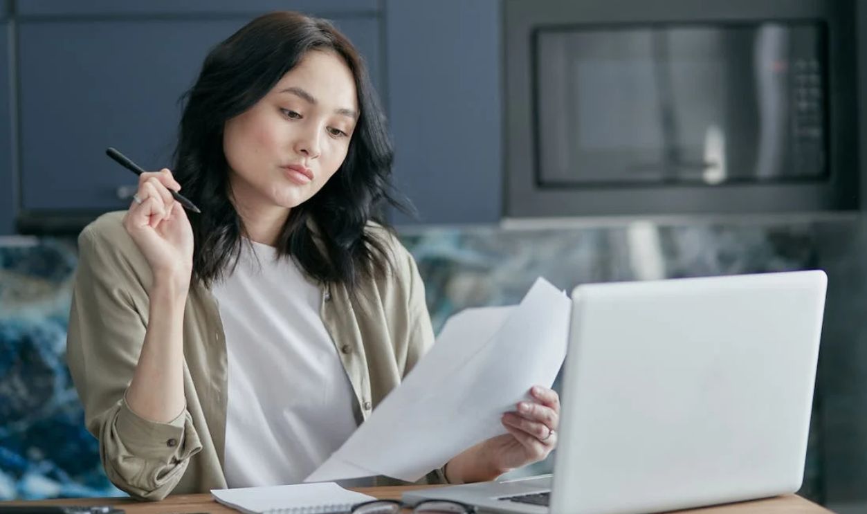 A Woman Looking at White Papers