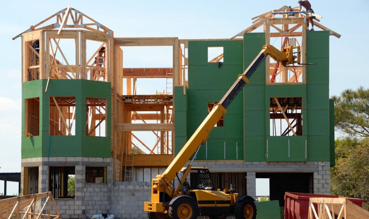 Yellow and Black Heavy Equipment Near Unfinished Building