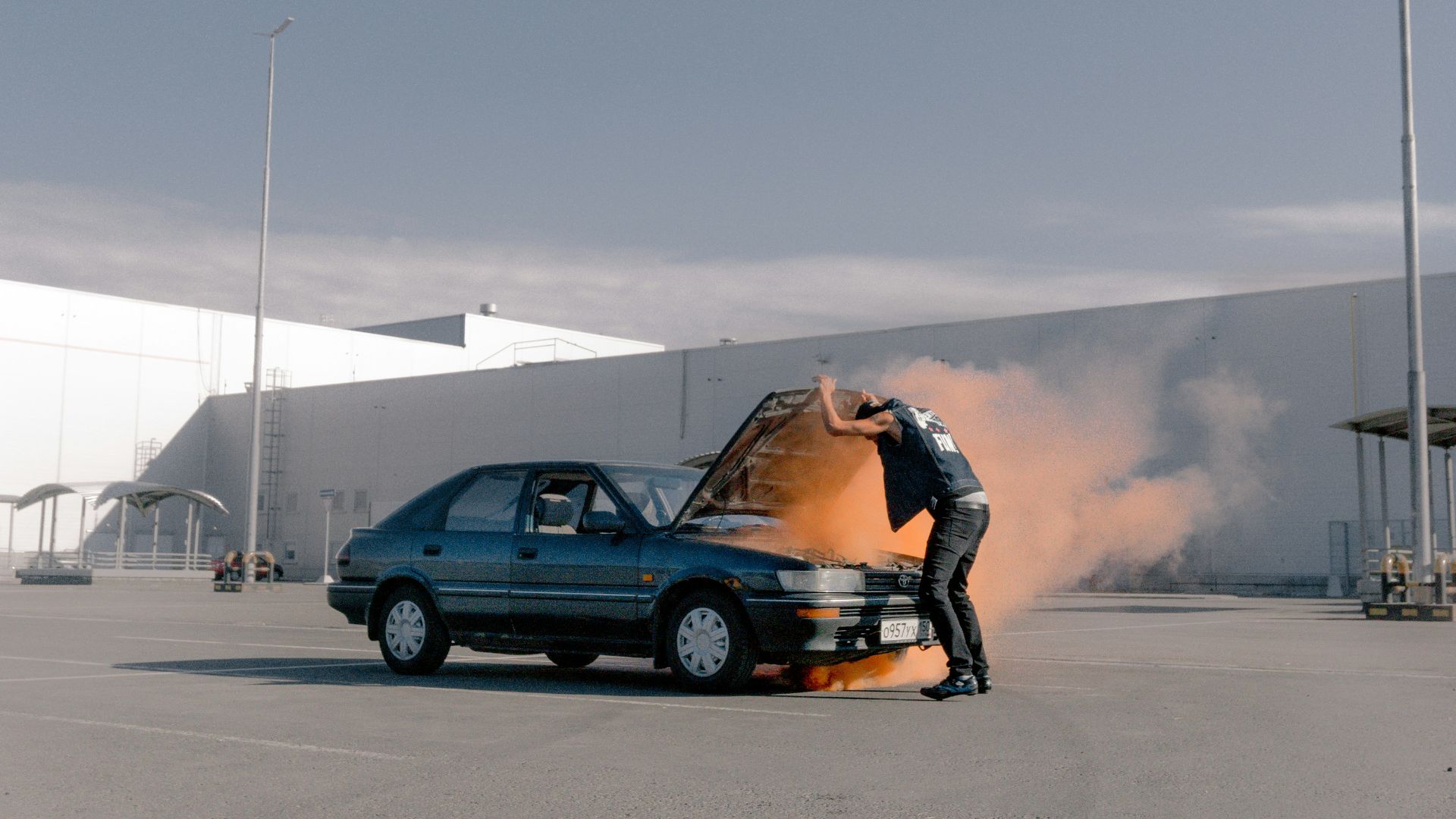man in black jacket and black pants sitting on black suv