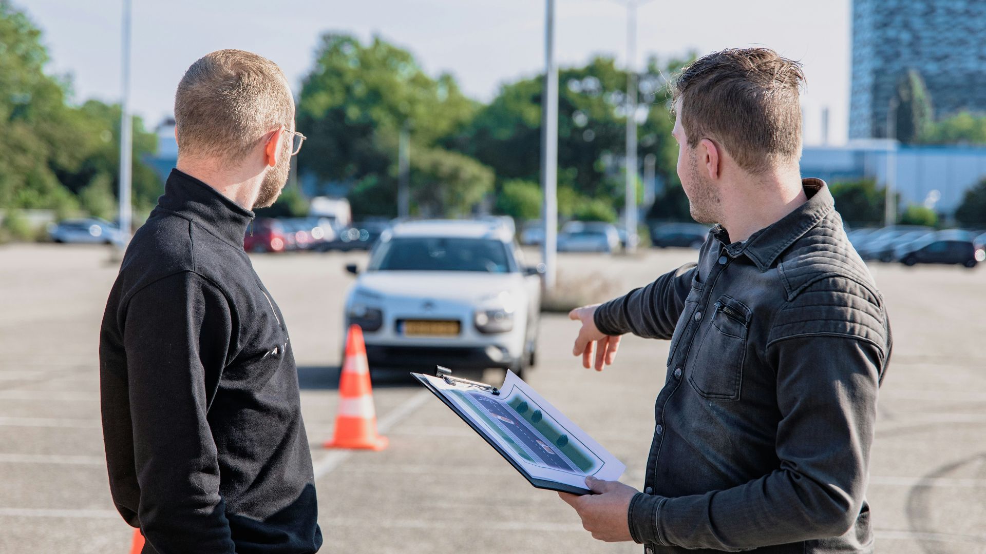 man in black jacket holding blue tablet computer