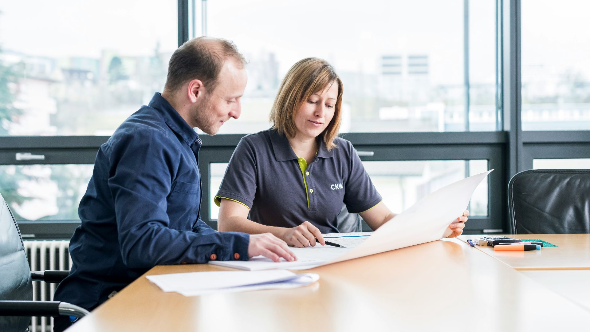 man in blue long sleeve shirt sitting beside woman in black long sleeve shirt