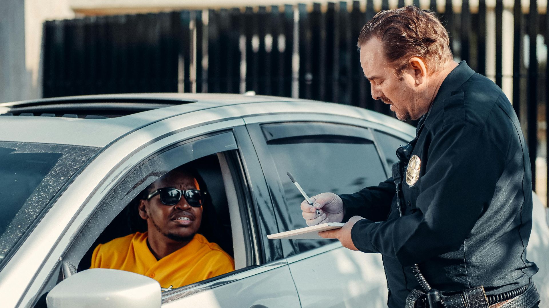 Police officer writes a traffic ticket for a driver during a routine stop.