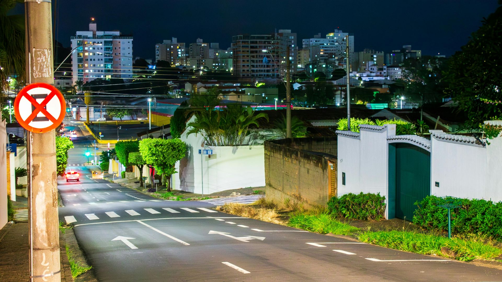 Vibrant night street scene in Uberlândia, Brazil showcasing illuminated buildings and road signs.