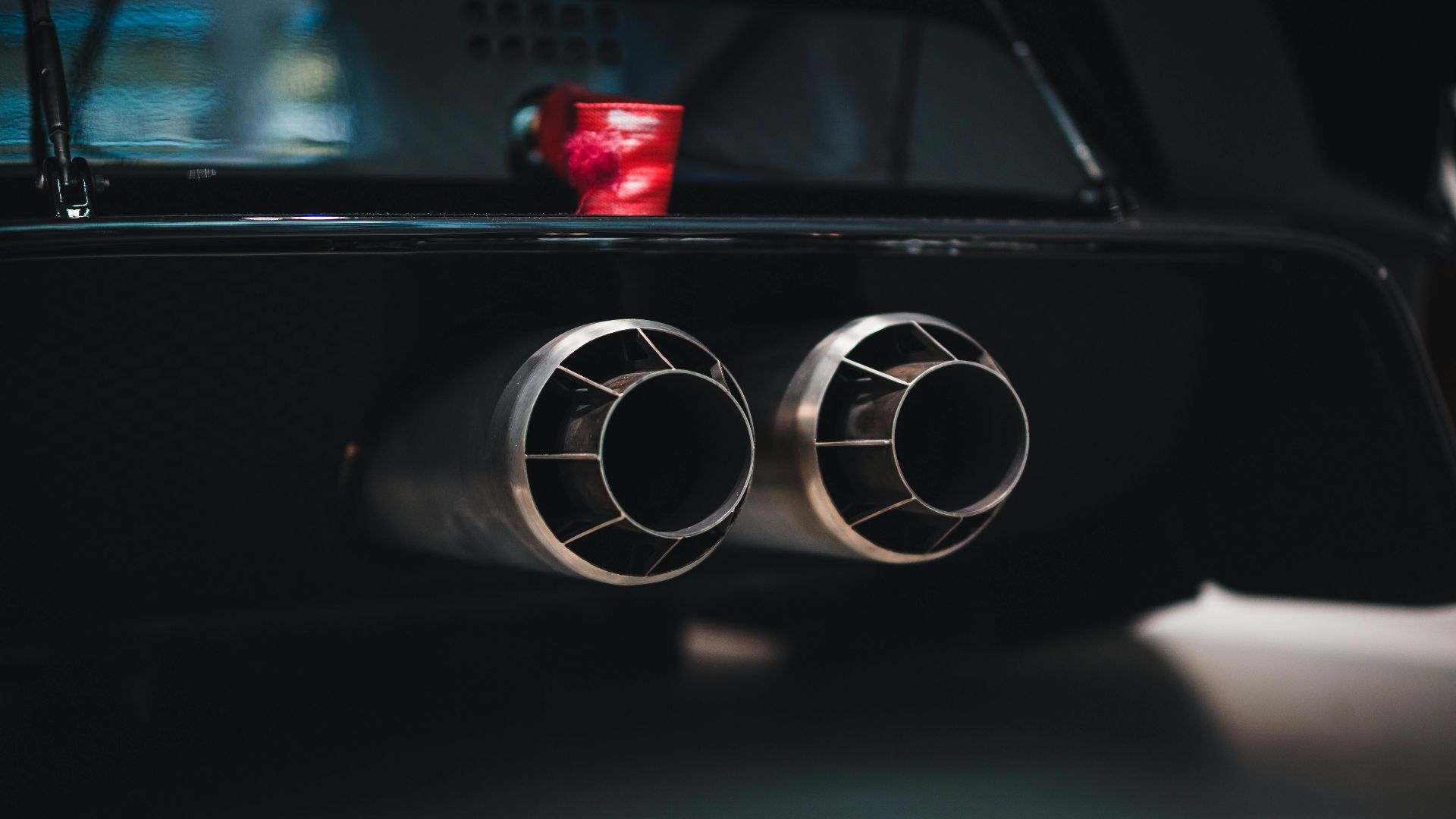 Close-up shot of dual exhaust pipes on a sleek car, with a focus on detail and design.