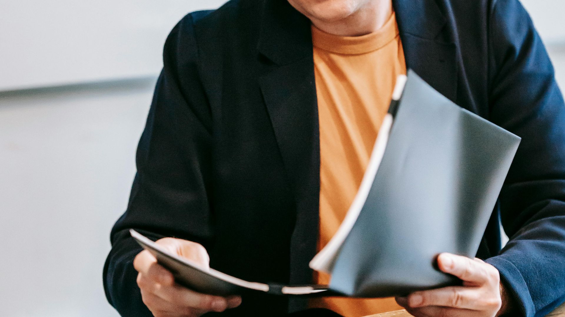 Businessman in a suit reviewing documents at an office desk, focused on work.