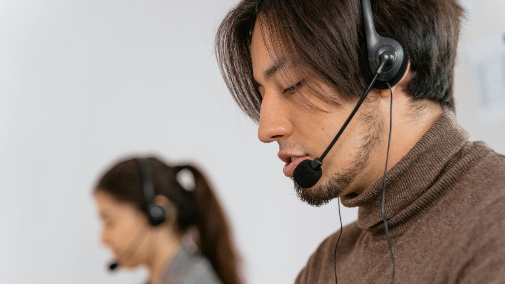 Focused call center employees wearing headsets, assisting customers with exceptional service.