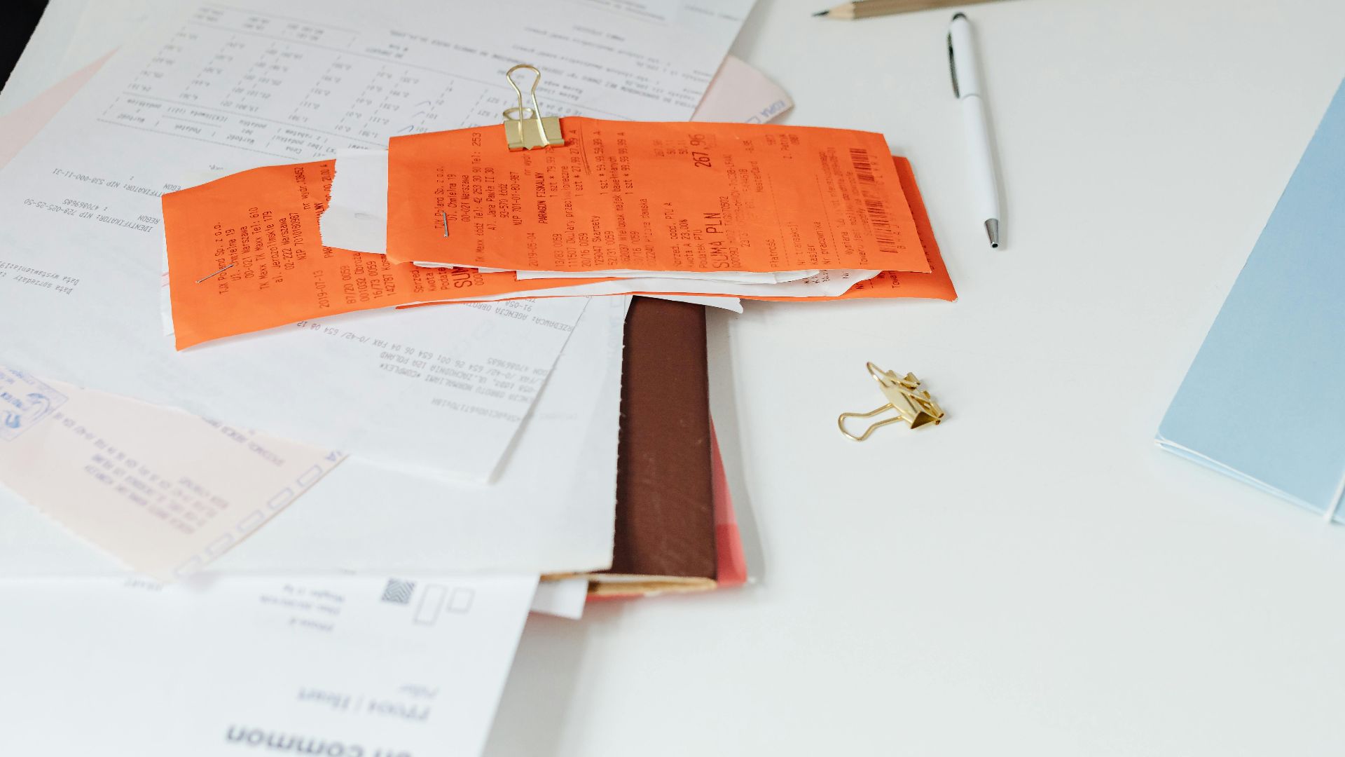 Close-up of a tidy desk with receipts, documents, and office stationery for business organization.