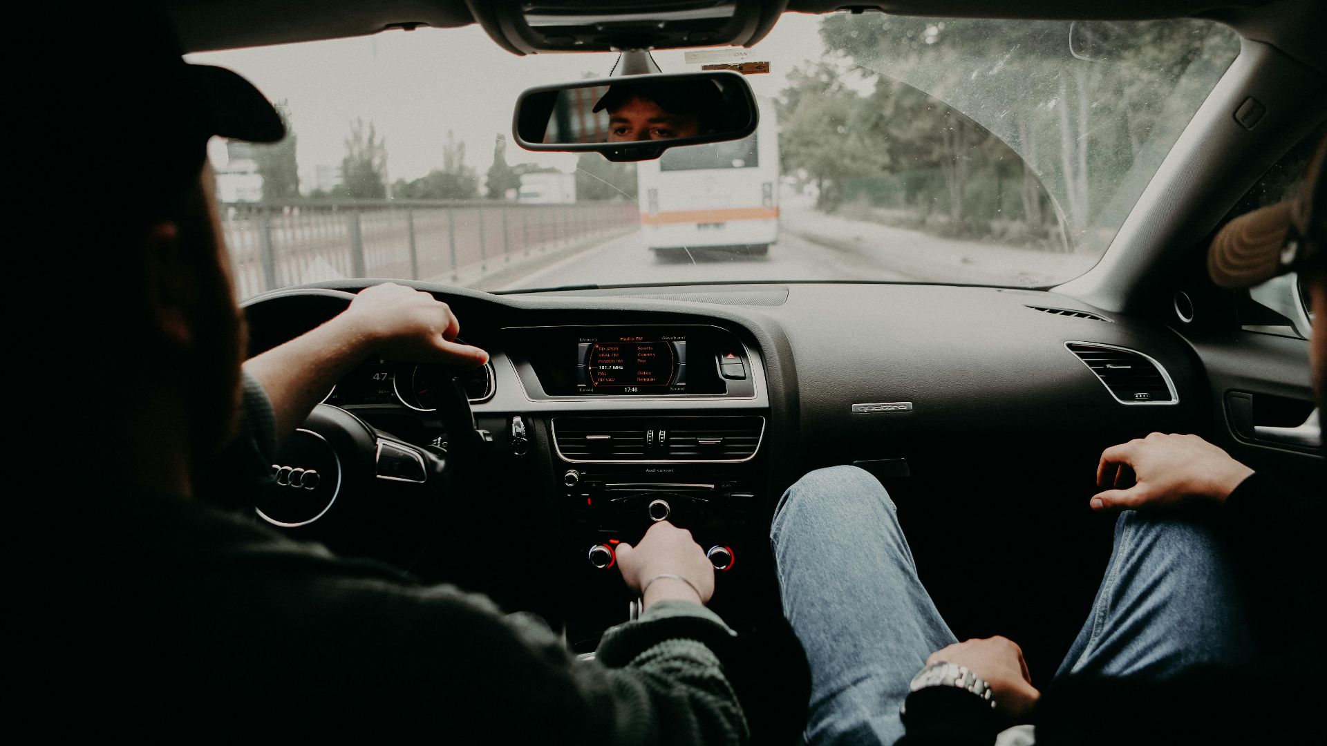 View from inside a moving car with two men traveling on a road trip.