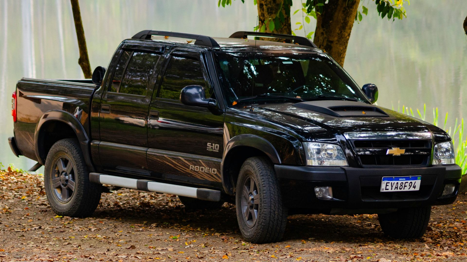 A black pickup truck parked amidst lush greenery in Porto Feliz, Brazil. Perfect for outdoor adventure.