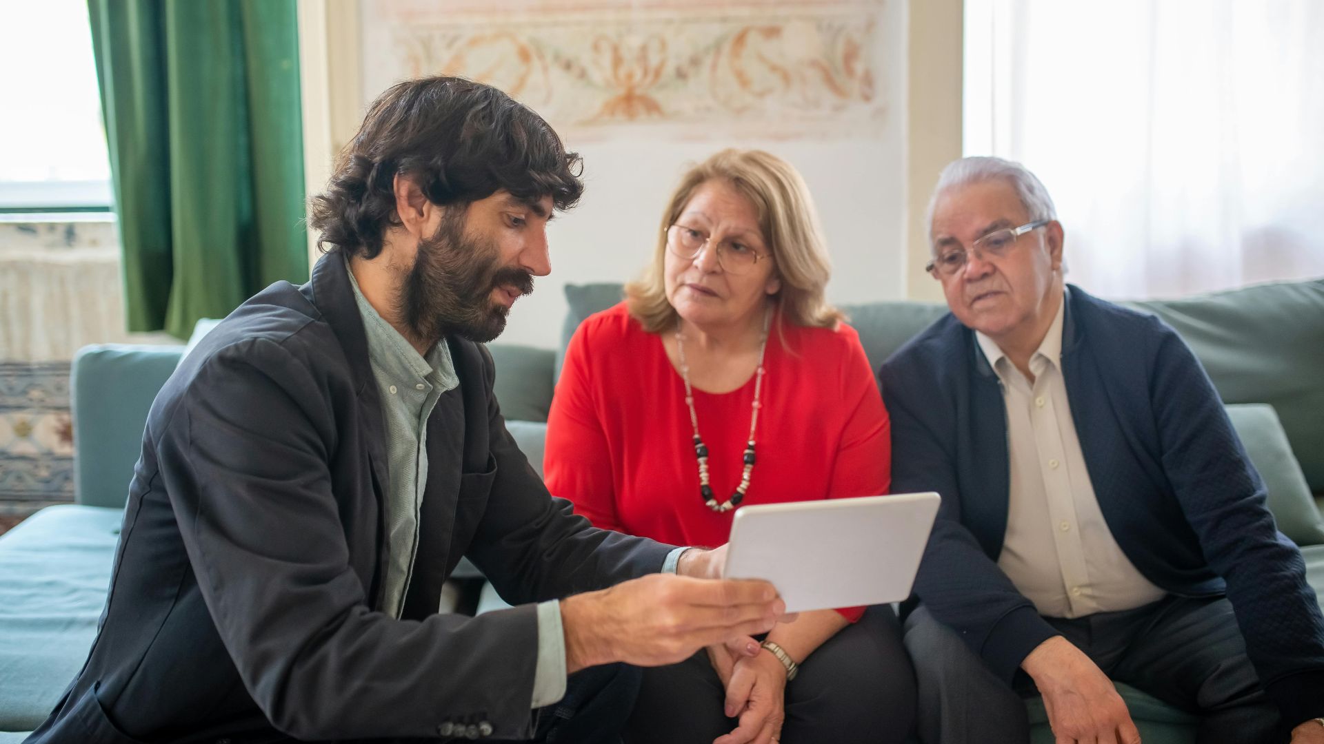 A financial advisor discussing investment options with an elderly couple in a cozy living room.