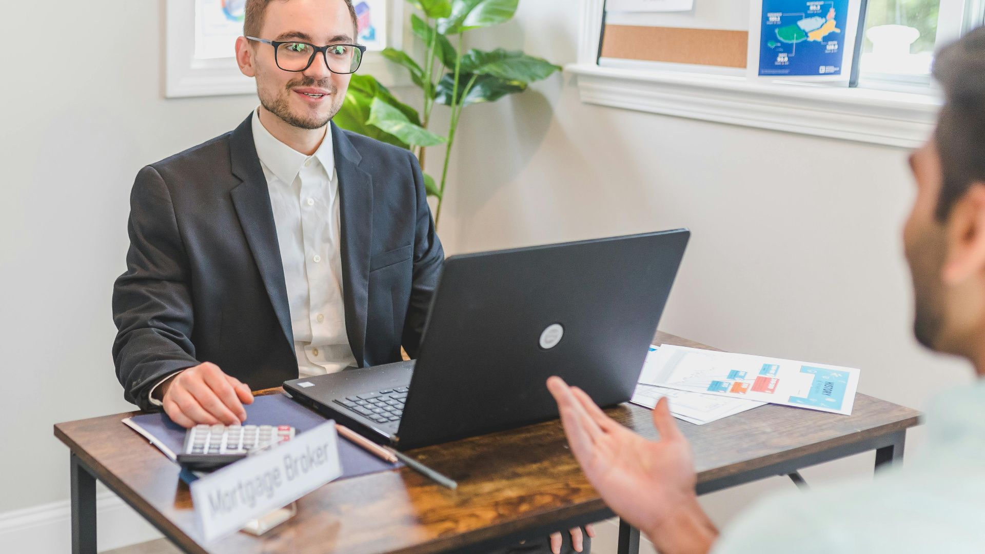 A mortgage broker and client discussing loan options in a modern office setting.