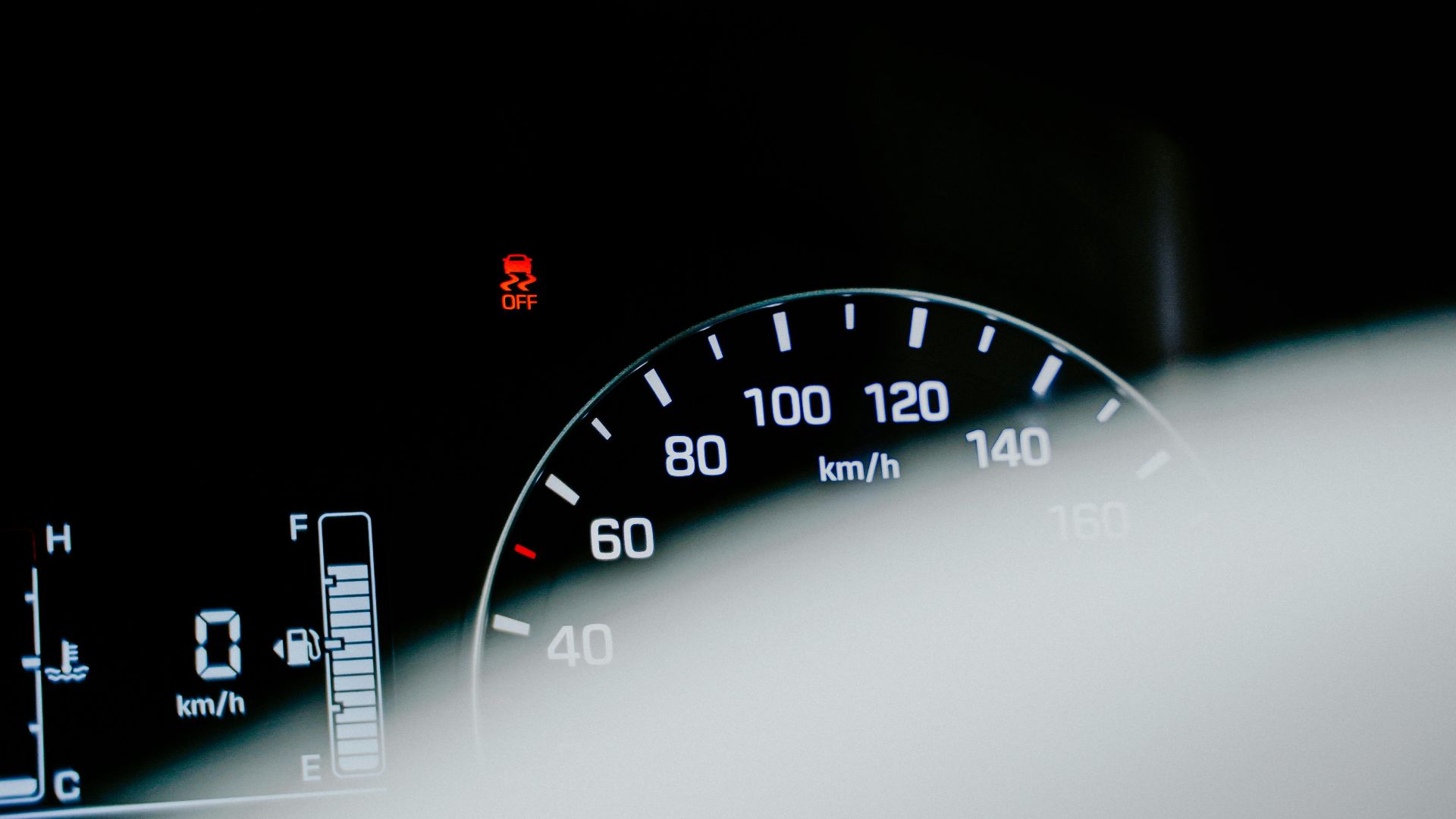 Detailed close-up of a car speedometer displaying a digital reading and warning light.