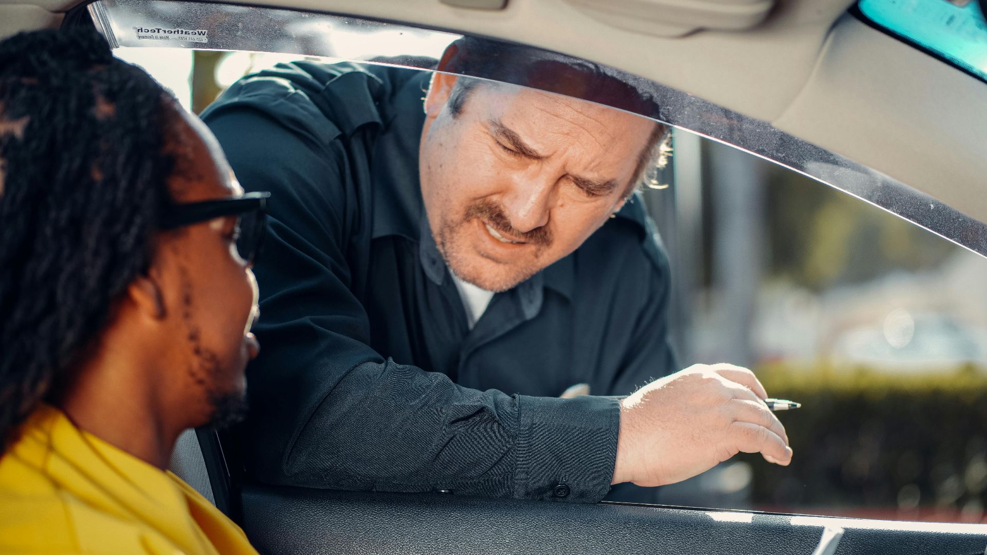 A police officer interacts with a driver through a car window, emphasizing law enforcement and public safety.