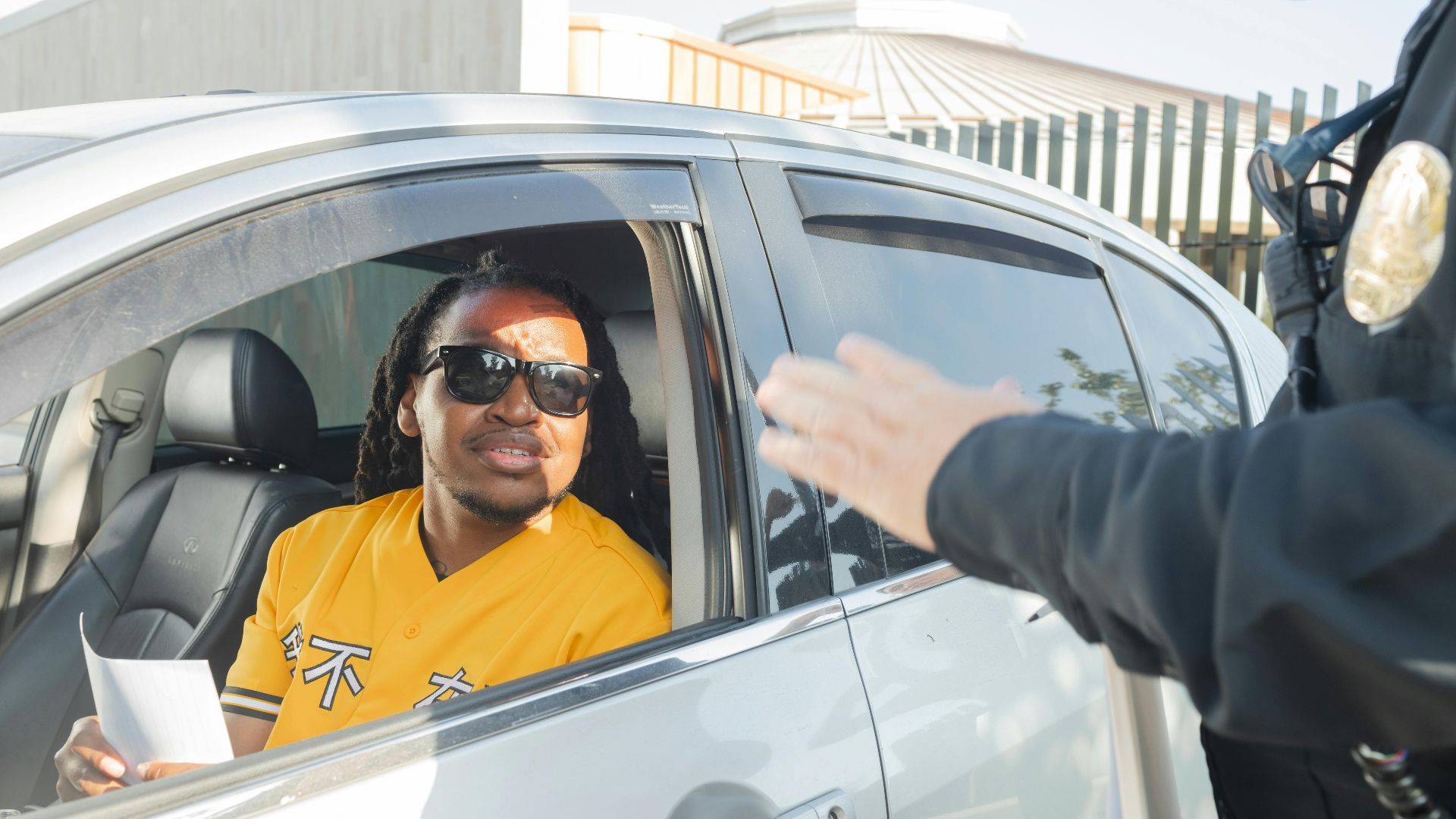 A police officer stops a driver for a traffic violation on a sunny day.