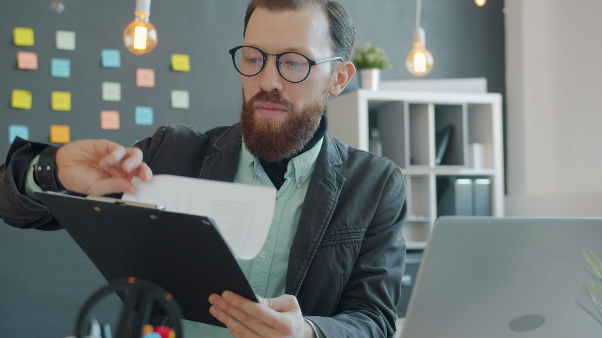 Man in glasses reviewing documents at desk