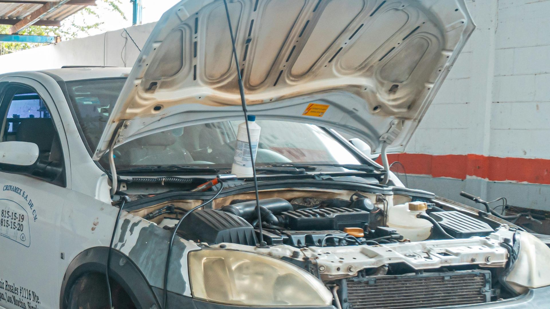 Indoor car repair garage with multiple vehicles under maintenance, showcasing a bustling automotive environment.
