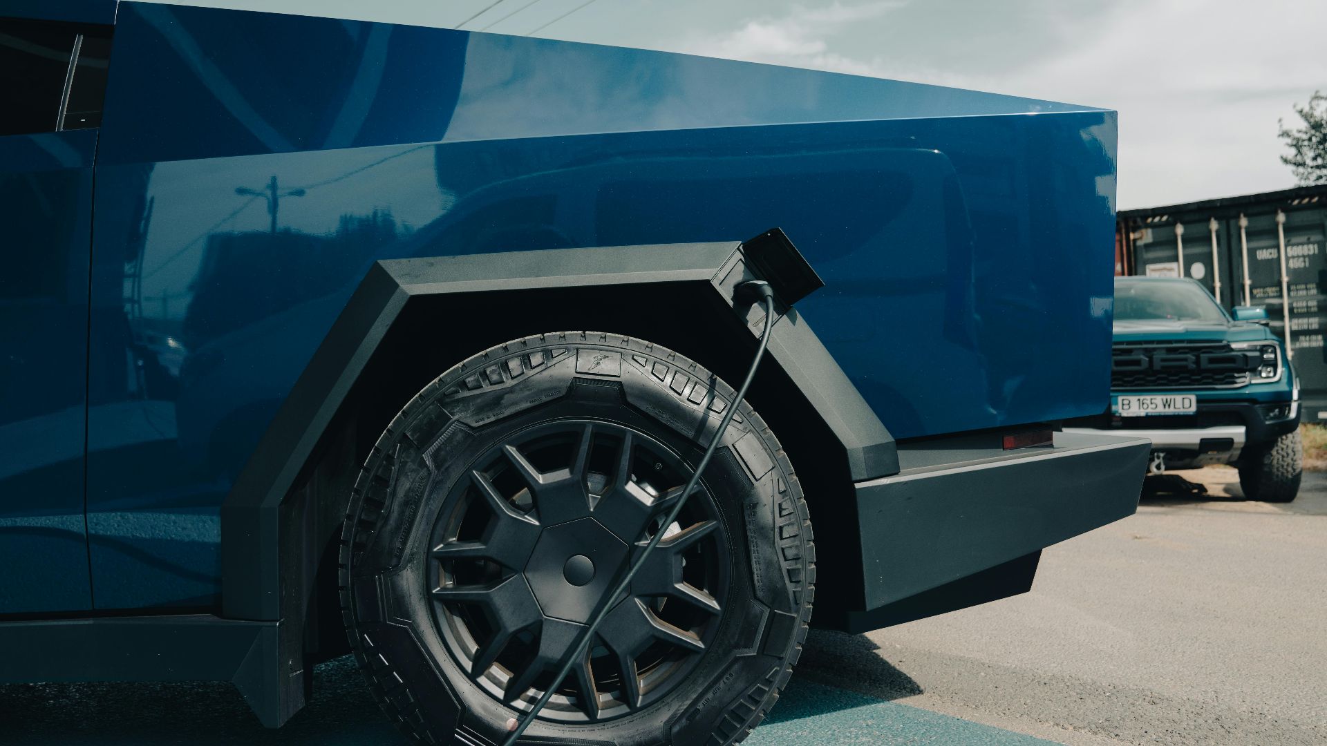 Close-up of a blue electric vehicle charging in Bucharest on a sunny day.