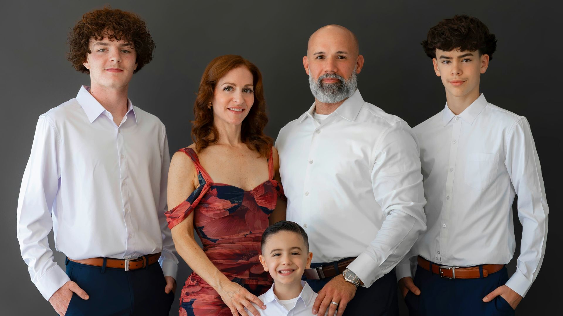 Family of five posing for a studio portrait.