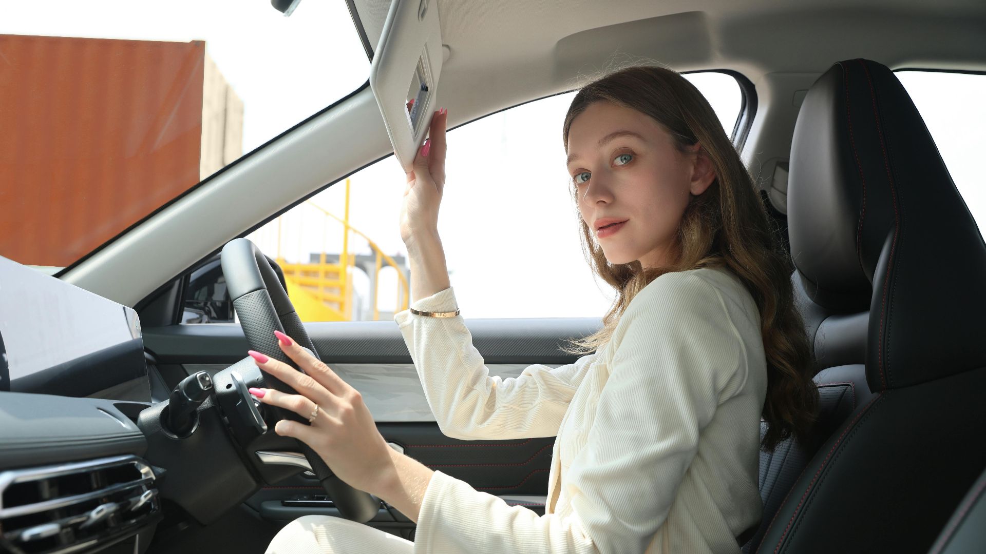 Stylish woman in an elegant car adjusting sun visor, emphasizing premium lifestyle and modern car interior.