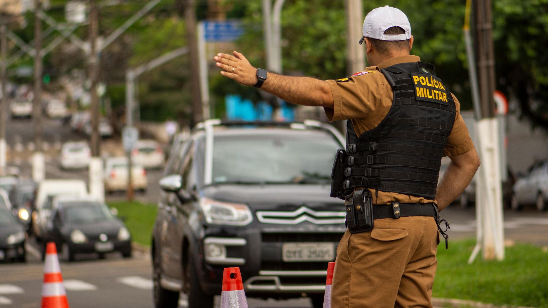 Police officer directing traffic on a busy street in Londrina, Brazil.