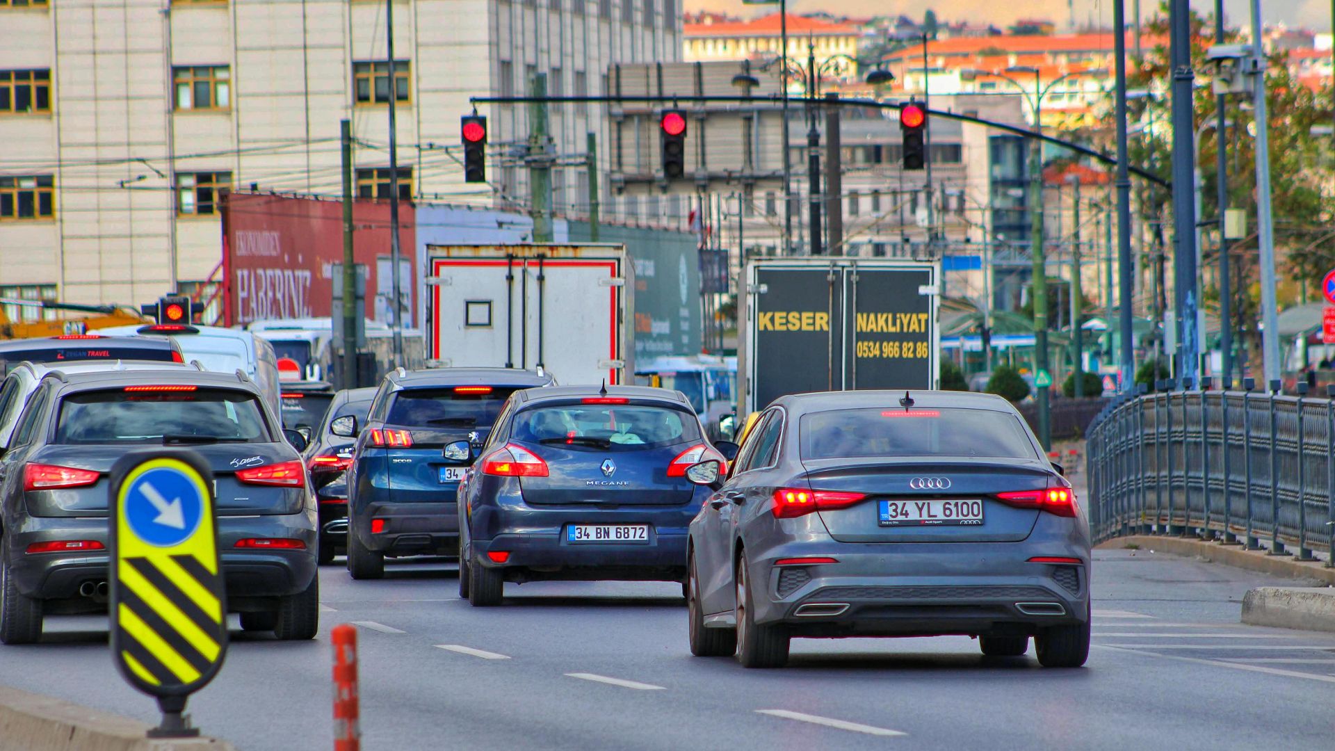 Heavy urban traffic jam with diverse vehicles and street signs.