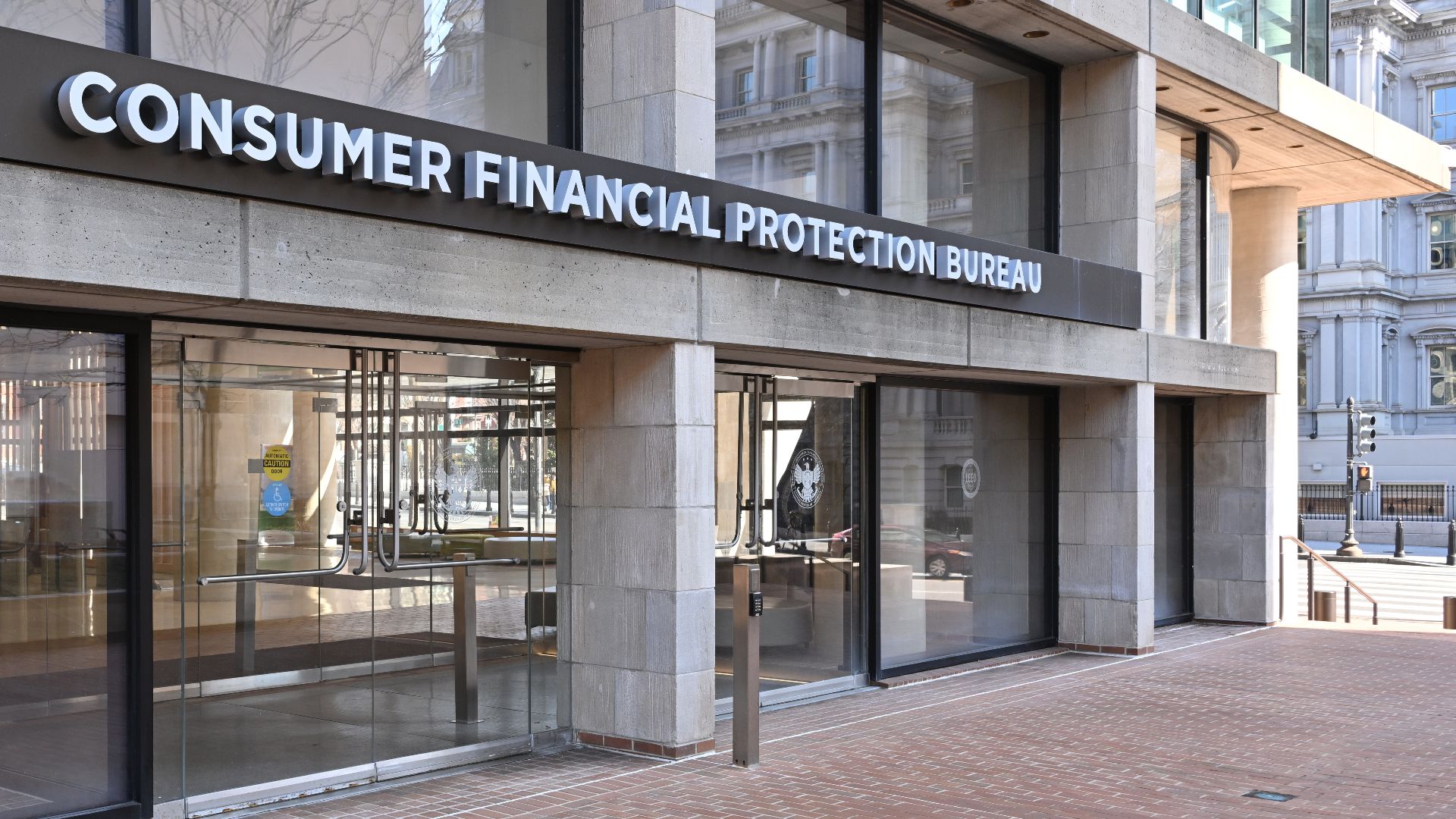 The entrance to the Consumer Financial Protection Bureau headquarters with the bureau's name above it. 1700 G Street NW, Washington, DC 20552.