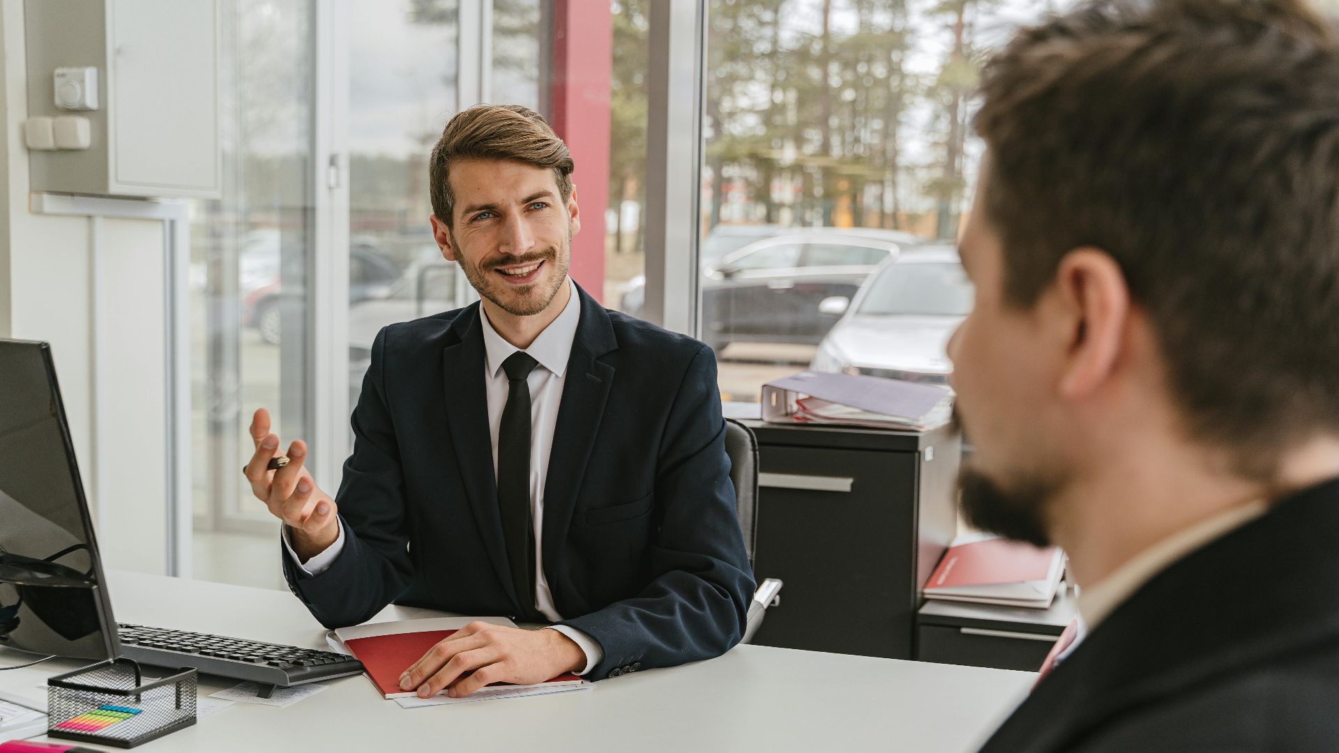 Two businessmen having a conversation in a modern office setting.