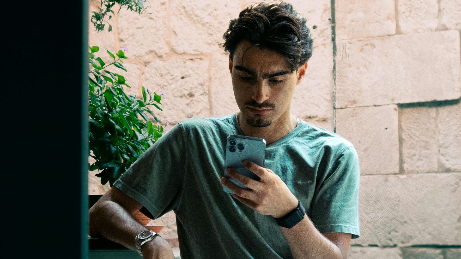 A young man in casual attire checking his phone outside in Split, Croatia.