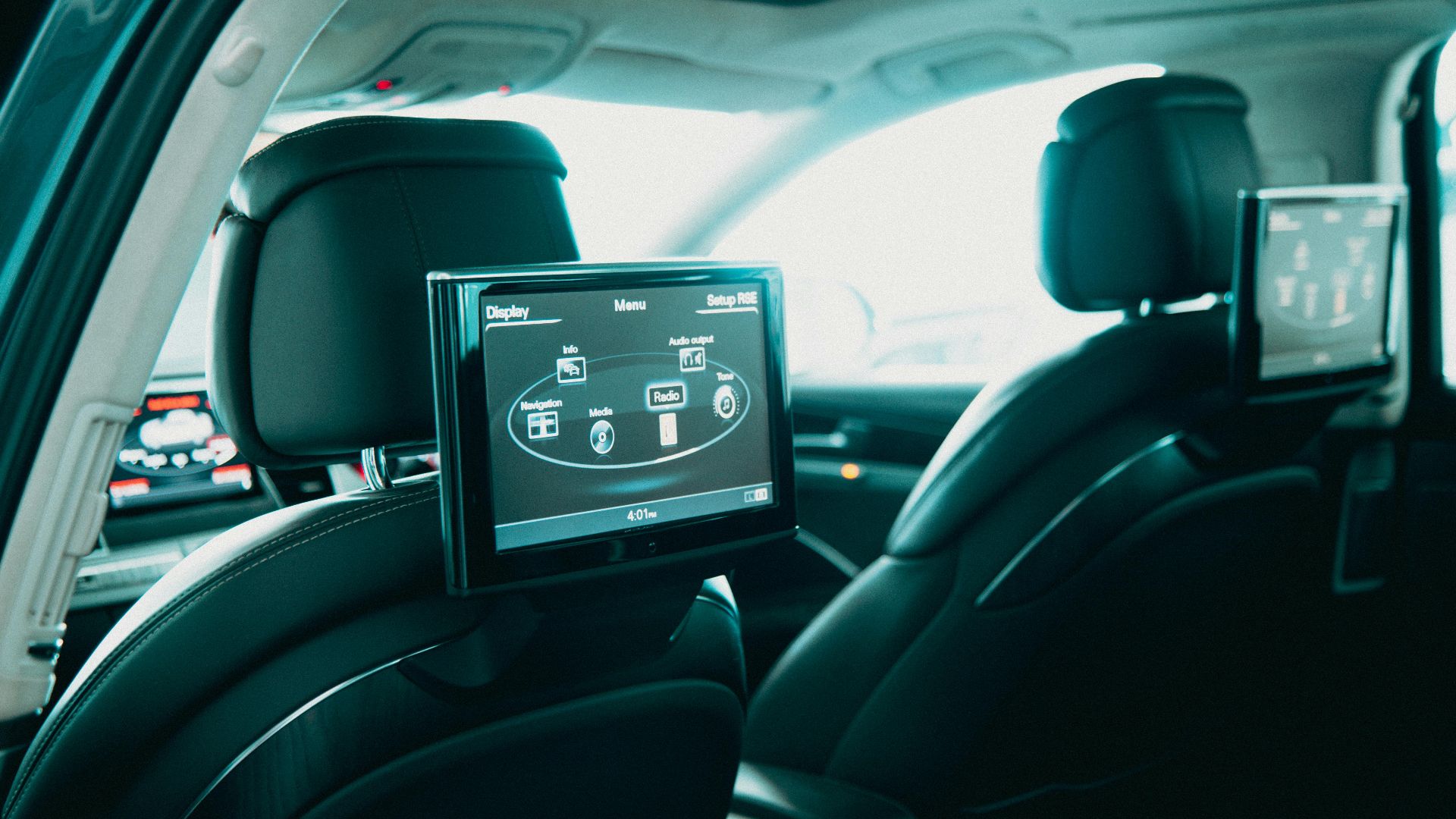 Spacious car interior featuring dual rear entertainment screens for backseat passengers.