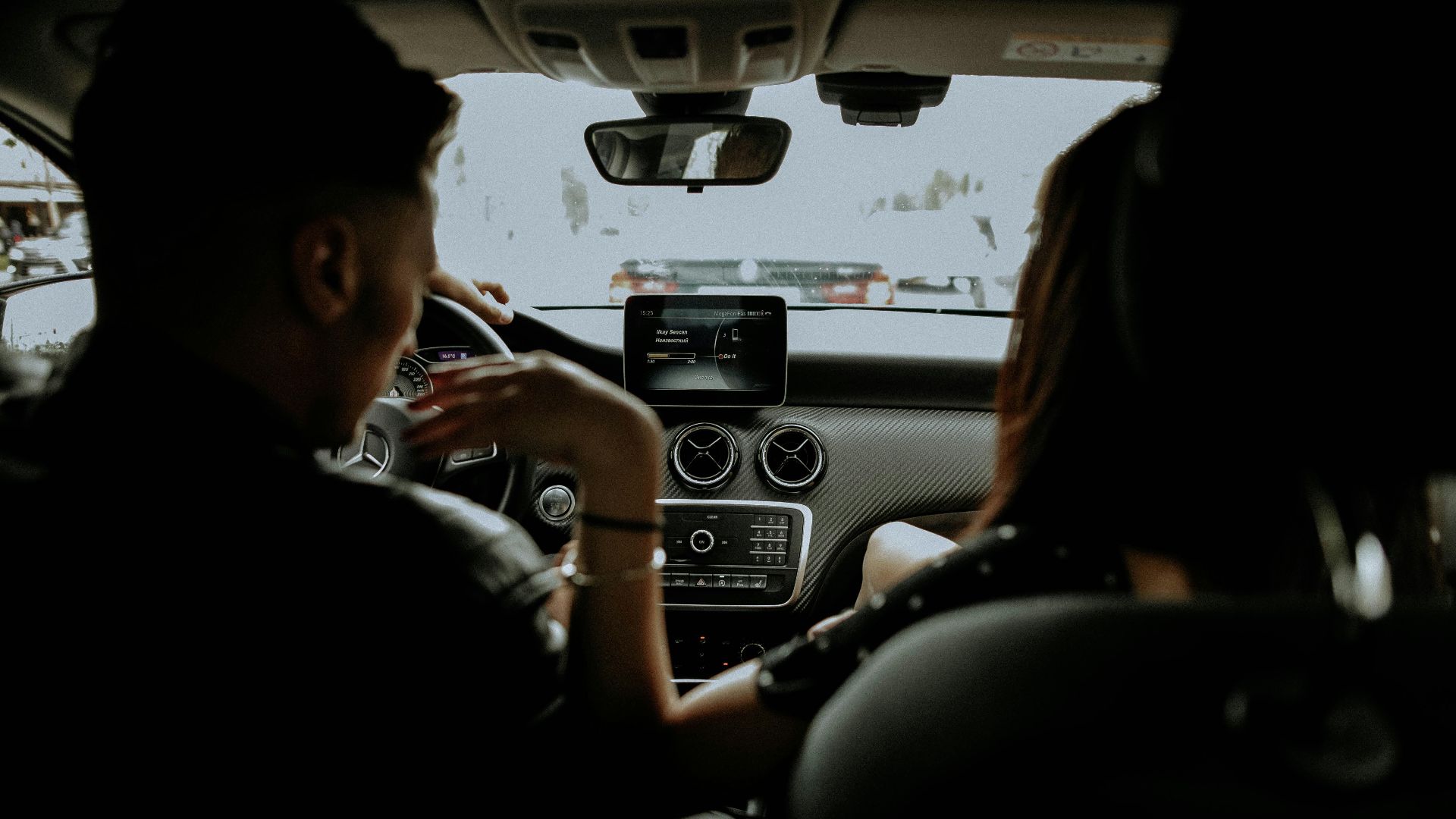 A couple enjoying a drive in a sleek modern car, showcasing the luxury interior.
