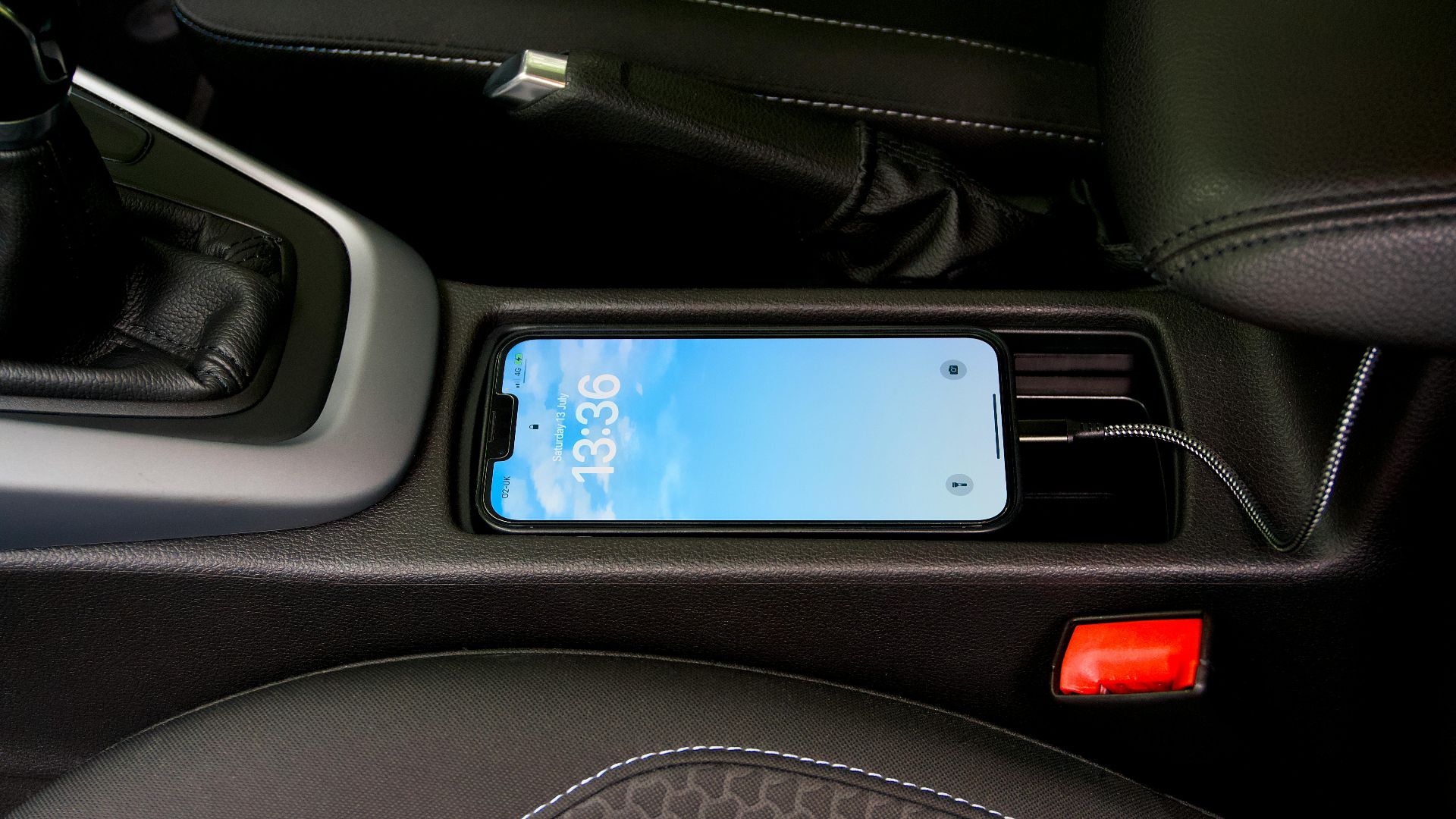A smartphone charging in a car's central console, showcasing modern automotive technology.