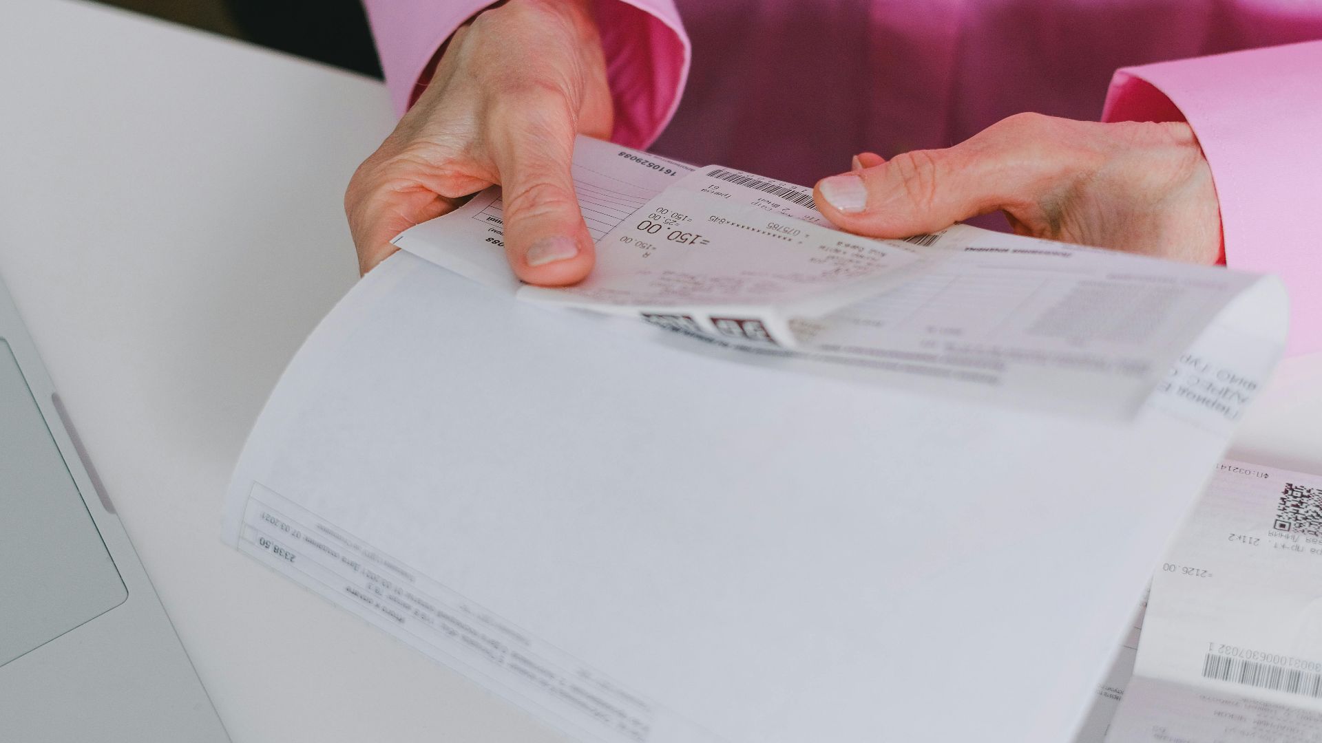 Business person handling paper receipts, meticulously organized.