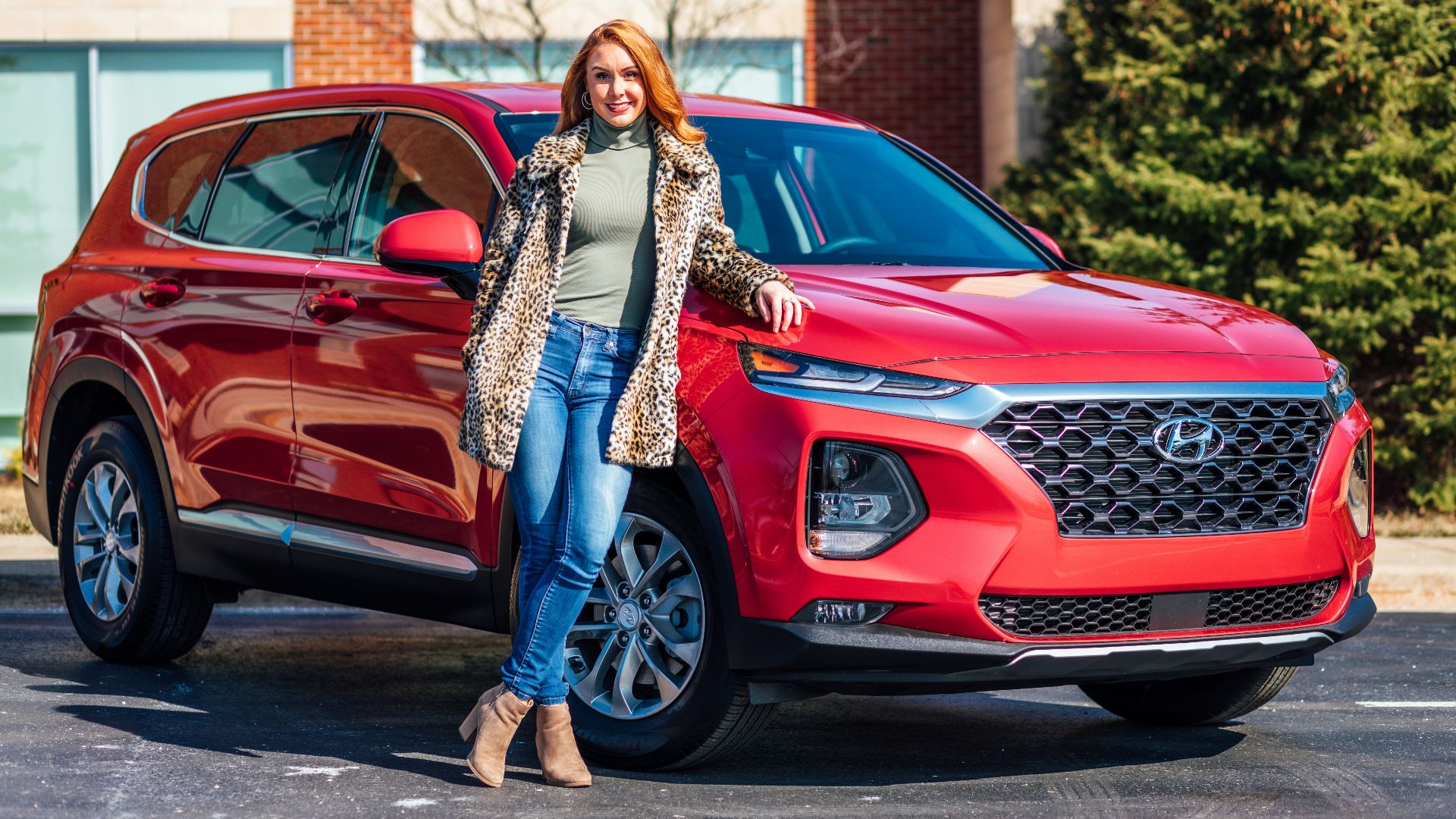 woman in white and black scarf and blue denim jeans standing beside red mercedes benz car
