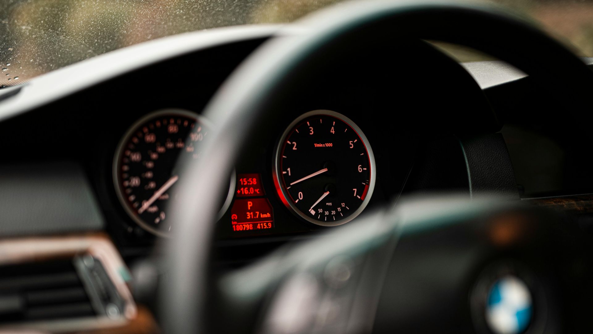 Detailed view of a car dashboard displaying speedometer and RPM gauges in focus.